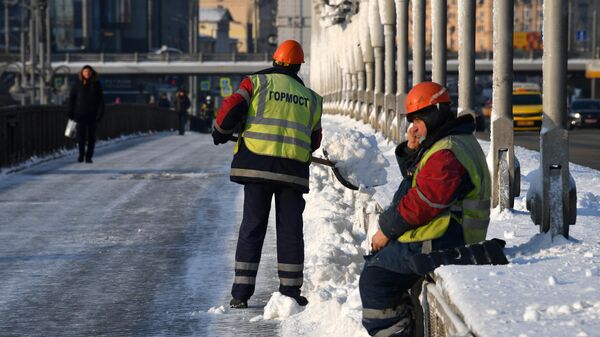 Сотрудники Гормоста убирают снег на Крымском мосту в Москве