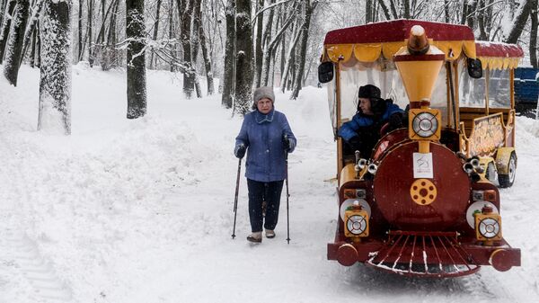 Жители города во время зимней прогулки в парке у Новгородского кремля