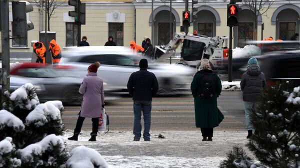 Люди переходят дорогу на одной из улиц в Москве. Архивное фото
