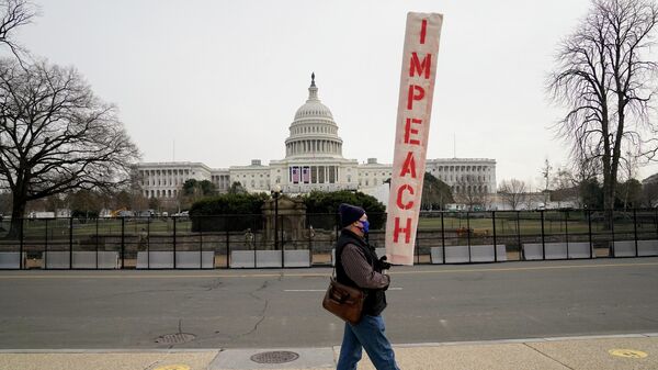 Демонстрант c табличкой Импичмент у здания Капитолия США в Вашингтоне