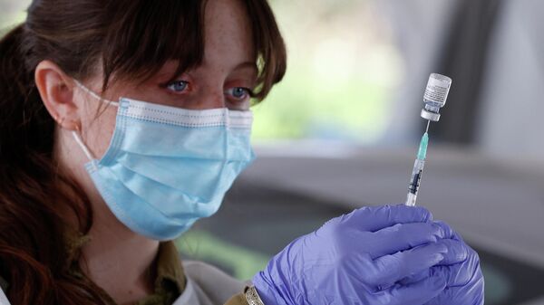 Медицинский работник готовит дозу вакцины Pfizer COVID-19 в прививочном центре Maccabi Health Services в Израиле