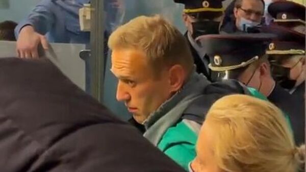 Сотрудники УФСИН задерживают Алексея Навального, прилетевшего из Берлина рейсом авиакомпании Победа, в международном аэропорту Шереметьево в Москве. Стоп-кадр с видео