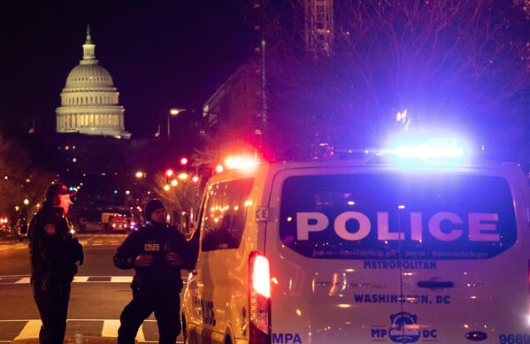 Полицейские дежурят на одной из улиц неподалеку от здания Капитолия в Вашингтоне