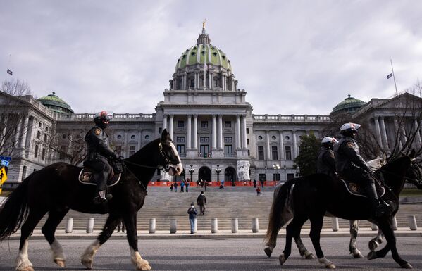 Конная полиция дежурит неподалеку от здания Капитолия штата Пенсильвания в Гаррисберге