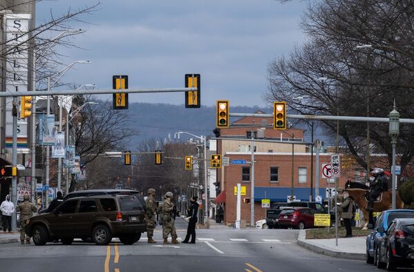 Военнослужащие Национальной гвардии и полиции дежурят на одной из улиц неподалеку от здания Капитолия штата Пенсильвания в Гаррисберге