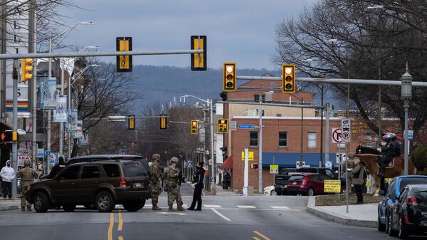 Военнослужащие Национальной гвардии и полиции дежурят на одной из улиц неподалеку от здания Капитолия штата Пенсильвания в Гаррисберге