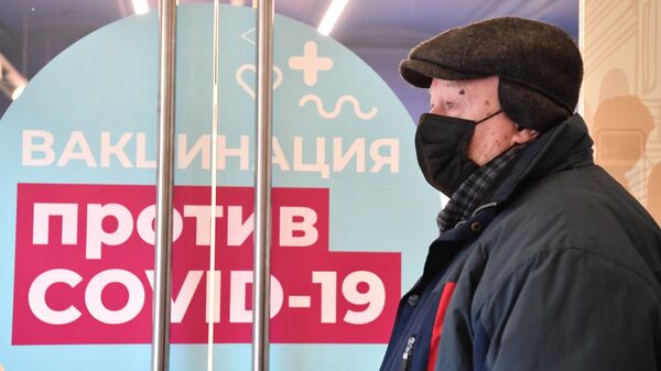 Мужчина возле пункта вакцинации от коронавируса в ГУМе в Москве