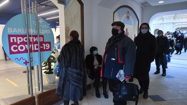 Люди возле пункта вакцинации от коронавируса в ГУМе в Москве