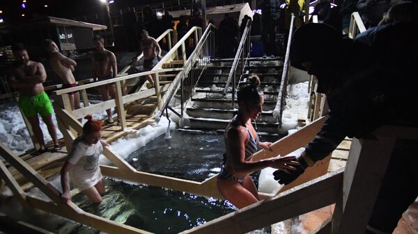Люди окунаются в купель во время крещенских купаний в Спортивной гавани во Владивостоке