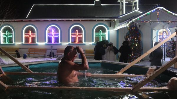Мужчина окунается в купель во время крещенских купаний в Симферополе, Россия