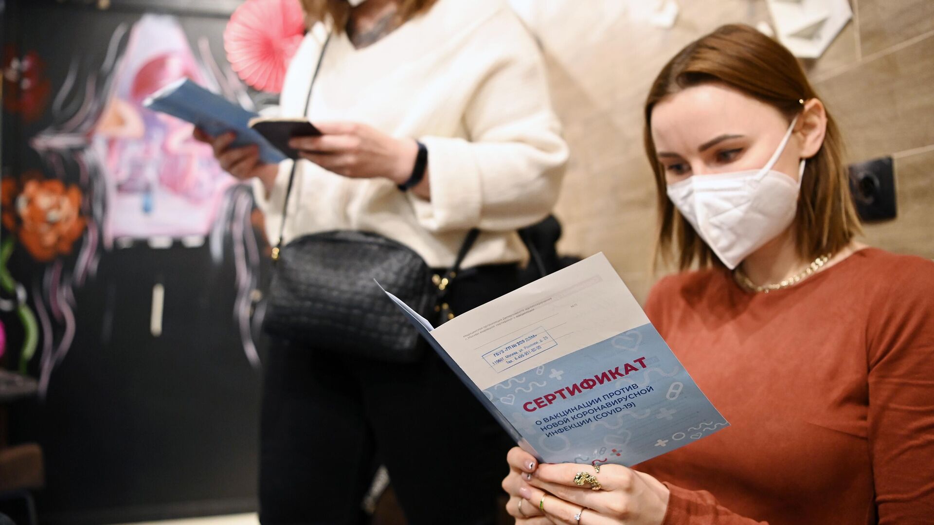 Девушки держат в руках сертификат о вакцинации от СOVID-19 в ТЦ Океания - РИА Новости, 1920, 20.01.2021