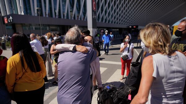 Люди обнимаются при встрече в международный аэропорт Эсейса на окраине Буэнос-Айреса 