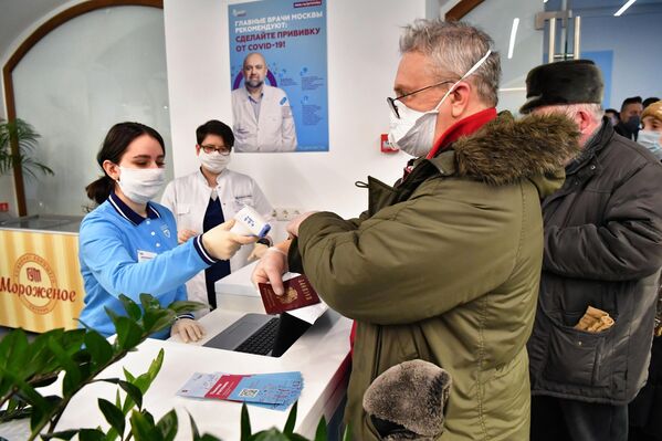 Измерение температуры при входе в пункт вакцинации от коронавируса в ГУМе в Москве