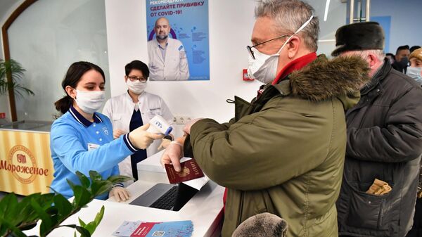 Измерение температуры при входе в пункт вакцинации от коронавируса в ГУМе в Москве