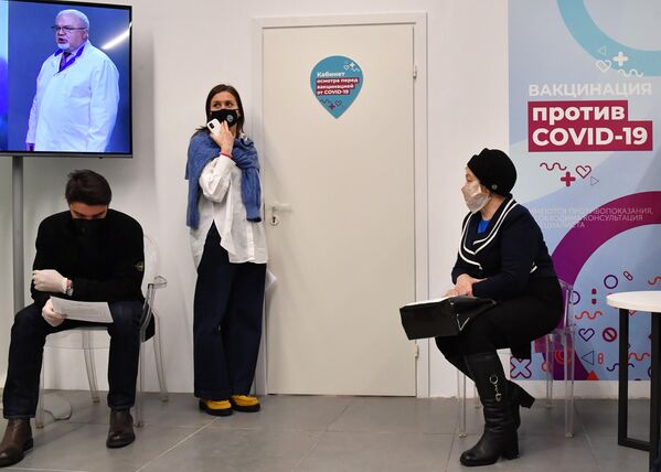 Люди возле пункта вакцинации от коронавируса в ГУМе в Москве