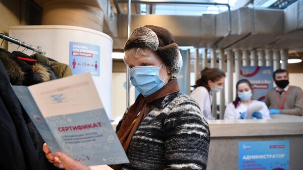 Женщина держит в руках сертификат о вакцинации от СOVID-19 на территории фудмолла Депо.Москва