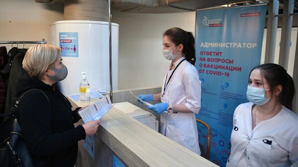 Женщина получает сертификат о вакцинации от СOVID-19 на территории фудмолла Депо.Москва