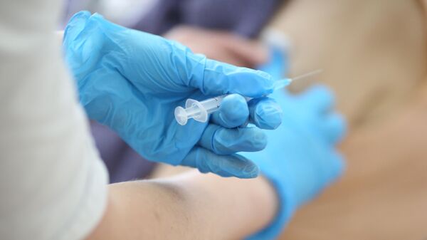 Медсестра делает прививку пациенту от коронавируса вакциной