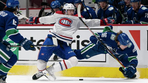 VANCOUVER, BC - JANUARY 20: Alexander Romanov #27 of the Montreal Canadiens and Adam Gaudette #96 of the Vancouver Canucks collide while battling for the loose puck during NHL hockey action at Rogers Arena on January 20, 2021 in Vancouver, Canada.   Rich Lam/Getty Images/AFP