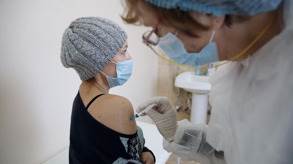 Женщина прививается от коронавируса вакциной Спутник-V (Гам-КОВИД-Вак) в Динской центральной районной больнице в Краснодарском крае