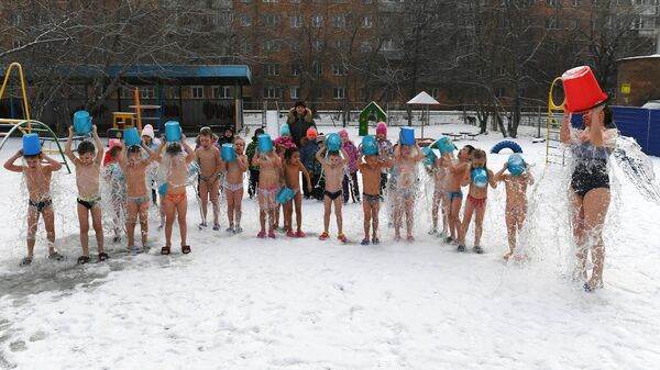 Дети обливаются холодной водой в детском саду No317 в Красноярске