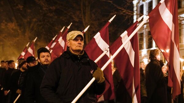 Участники факельного шествия в честь Дня независимости Латвии в Риге