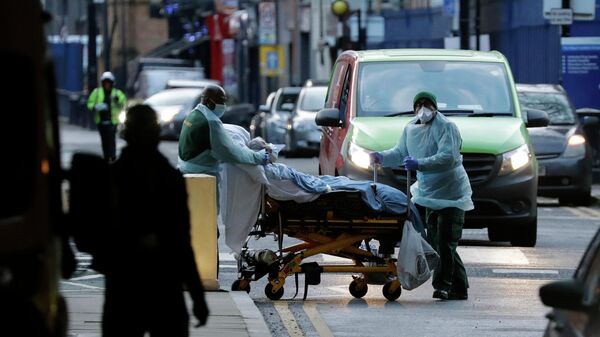 Медицинские работники транспортируют пациента на улице Лондона, Великобритания