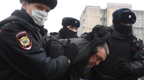 Сотрудники правоохранительных органов задерживают участника несанкционированной акции сторонников Алексея Навального в Москве