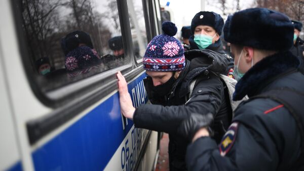 Сотрудники полиции задерживают участника несанкционированной акции сторонников Алексея Навального в Москве