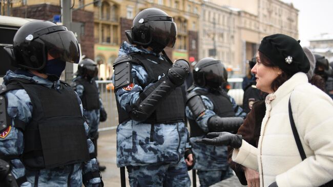 Женщина разговаривает с сотрудниками правоохранительных органов на Тверской улице в Москве