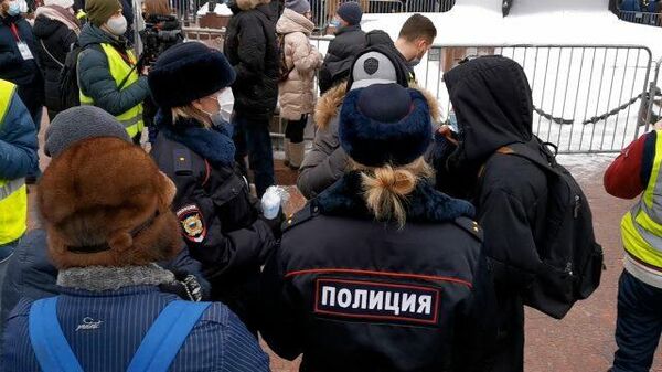 Девушки-полицейские раздают маски участникам несогласованной акции в Москве 