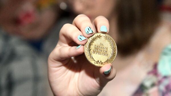 Выпускница общеобразовательной школы демонстрирует золотую медаль 