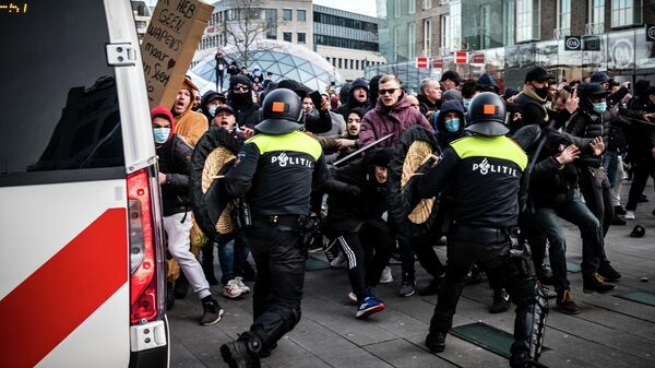 Столкновения протестующих с полицией во время демонстрации против коронавирусных ограничений на площади в Эйндховене, Нидерланды