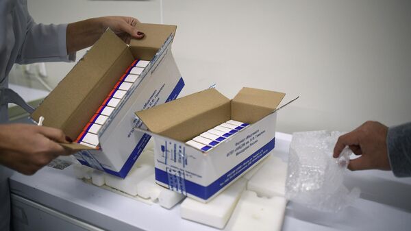 Сотрудница упаковывает вакцину Гам-КОВИД-Вак (торговая марка Спутник V) для отправки за границу