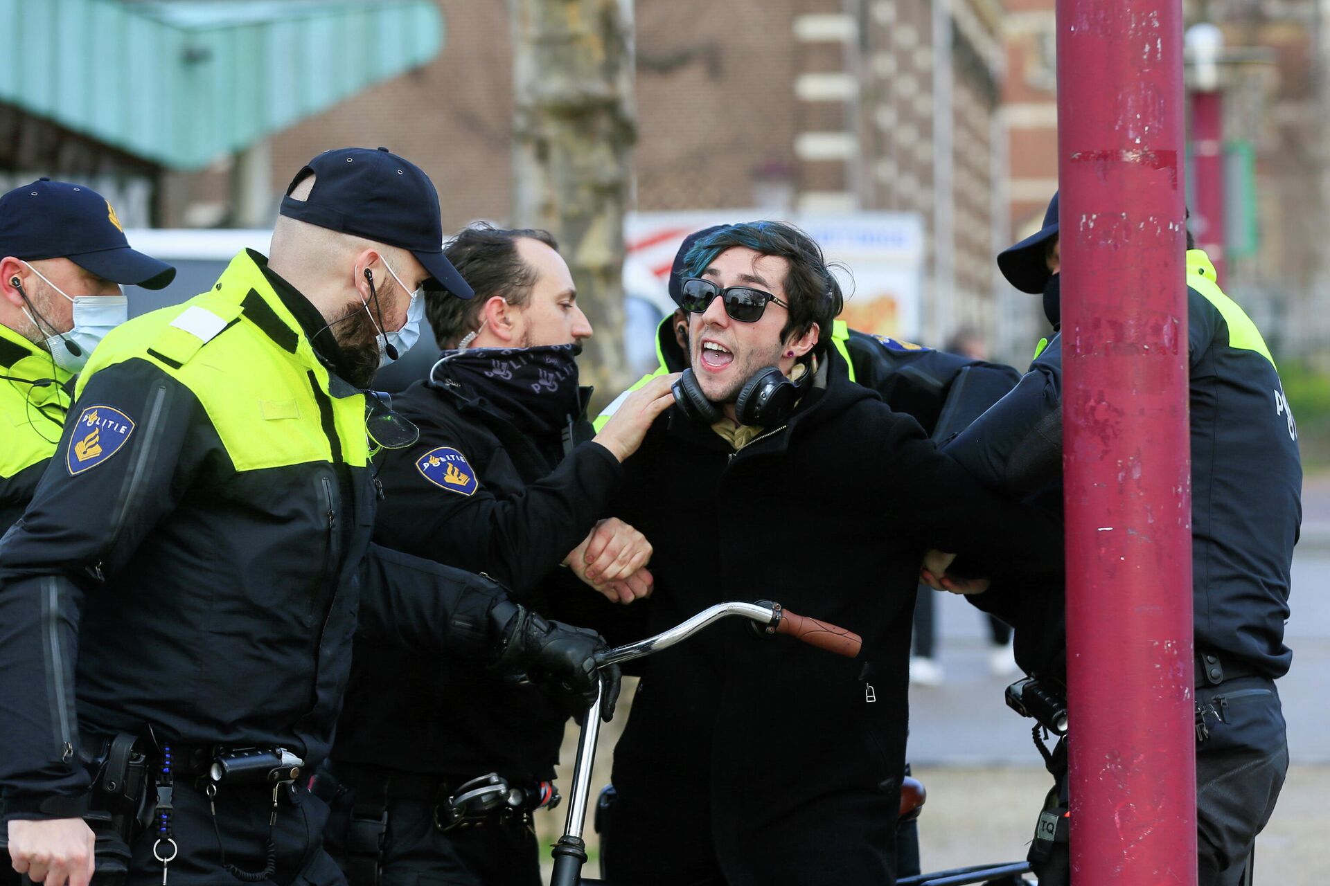 Полицейские во время задержания участника акции протеста против ограничений, введенных для сдерживания распространения коронавируса в Амстердаме - РИА Новости, 1920, 27.01.2021
