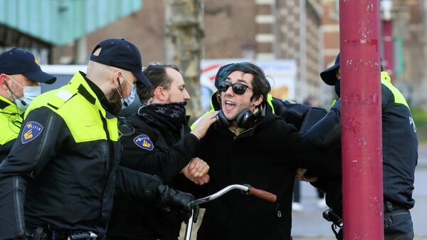 Полицейские во время задержания участника акции протеста против ограничений, введенных для сдерживания распространения коронавируса в Амстердаме