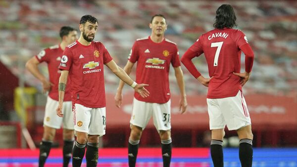 Manchester United's Portuguese midfielder Bruno Fernandes (L) and teammates react after conceding their second goal during the English Premier League football match between Manchester United and Sheffield United at Old Trafford in Manchester, north west England, on January 27, 2021. (Photo by Dave Thompson / POOL / AFP) / RESTRICTED TO EDITORIAL USE. No use with unauthorized audio, video, data, fixture lists, club/league logos or 'live' services. Online in-match use limited to 120 images. An additional 40 images may be used in extra time. No video emulation. Social media in-match use limited to 120 images. An additional 40 images may be used in extra time. No use in betting publications, games or single club/league/player publications. / 