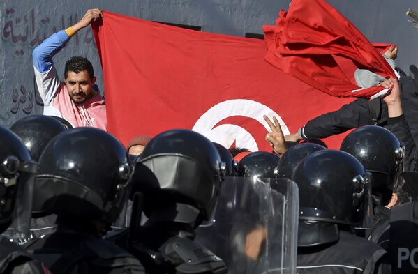 Сотрудники полиции блокируют протестующим доступ в здание парламента в Тунисе