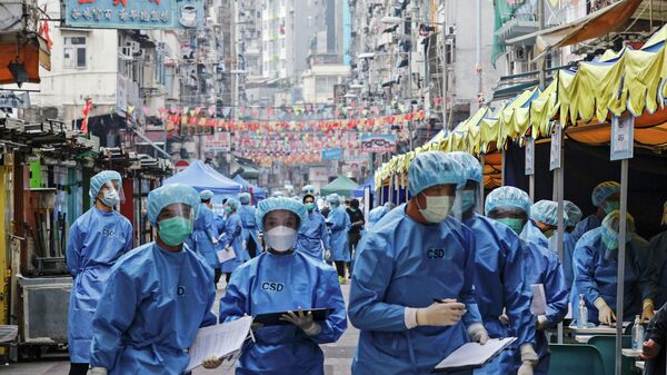 Медицинские работники в защитных костюмах в жилом районе Гонконга, закрытом в связи с распространением коронавируса