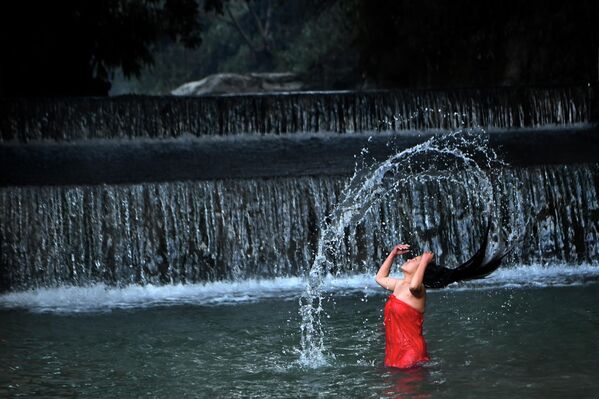 Девушка купается в реке Шали во время фестиваля Свастхани Брата Катха в Катманду