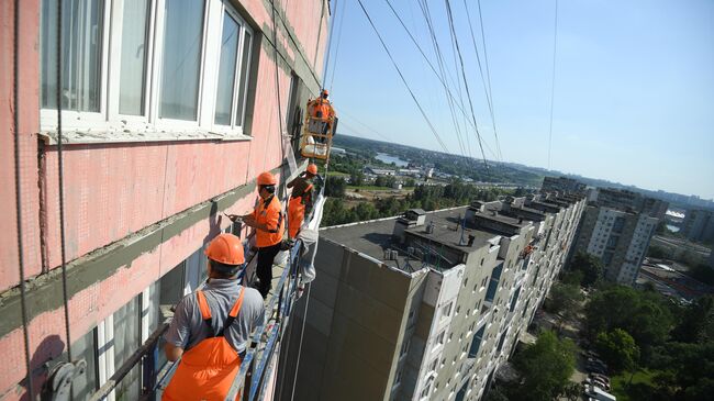 Рабочие проводят ремонт жилого дома