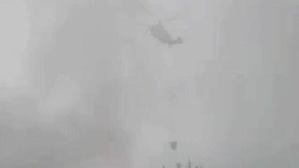 Пожарный вертолет сбрасывает воду на горящий топливозаправщик в Москве