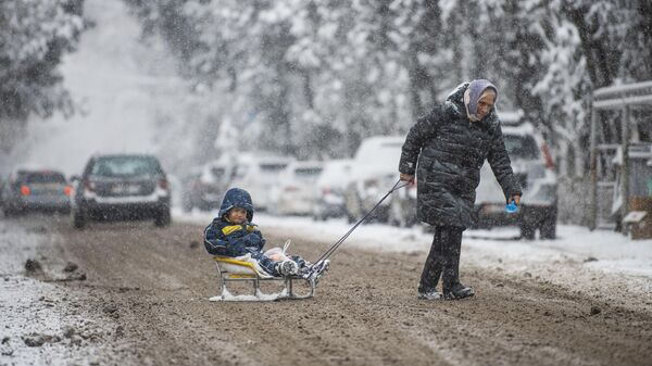 Женщина с ребенком переходит дорогу
