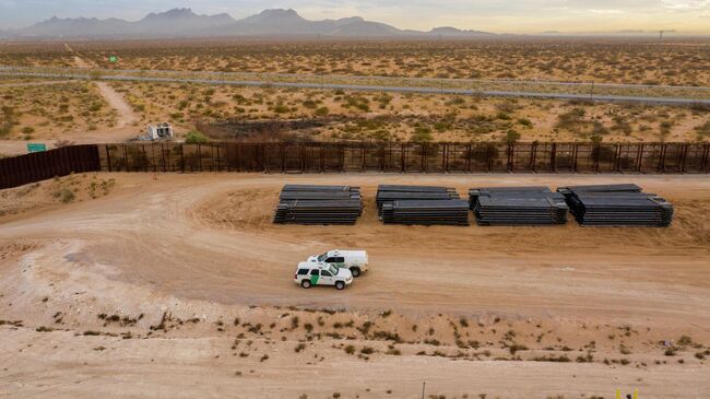 Машины пограничного патруля США едут вдоль конструкций недостроенной стены на границе между США и Мексикой