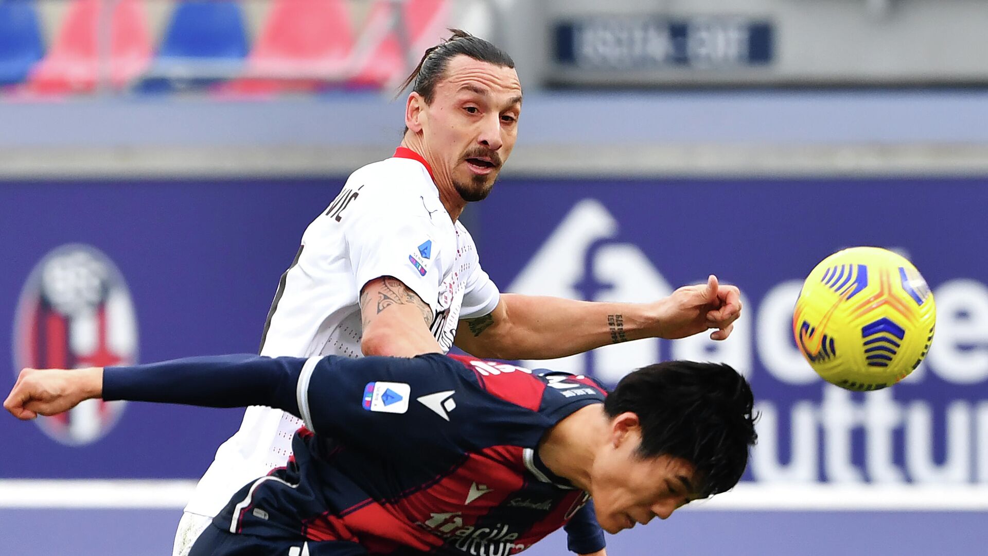 Bologna's Japanese defender Takehiro Tomiyasu (R) heads the ball past AC Milan's Swedish forward Zlatan Ibrahimovic during the Serie A football match between Bologna and AC Milan on January 30, 2021 at the Dall'Ara stadium in Bologna. (Photo by Alberto PIZZOLI / AFP) - РИА Новости, 1920, 30.01.2021