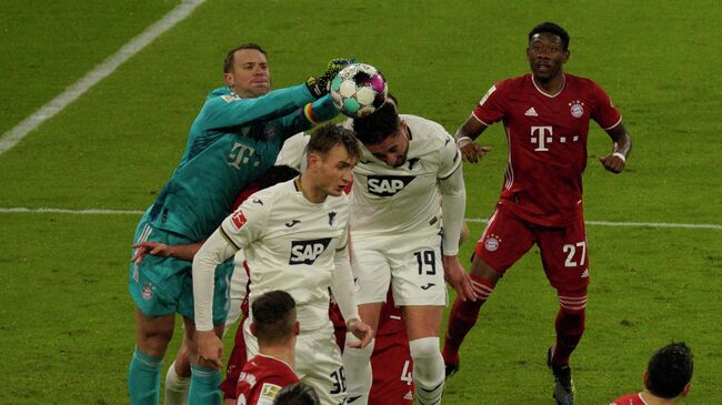 Bayern Munich's German goalkeeper Manuel Neuer (L) jumps to save the ball during the German first division Bundesliga football match FC Bayern Munich v TSG 1899 Hoffenheim in Munich, southern Germany on January 30, 2021. (Photo by GUENTER SCHIFFMANN / various sources / AFP) / DFL REGULATIONS PROHIBIT ANY USE OF PHOTOGRAPHS AS IMAGE SEQUENCES AND/OR QUASI-VIDEO