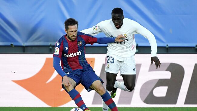 Levante's Spanish midfielder Jorge Miramon (L) vies with Real Madrid's French defender Ferland Mendy during the Spanish league football match Real Madrid CF against Levante UD at the Alfredo di Stefano stadium in Valdebebas, on the outskirts of Madrid on January 30, 2021. (Photo by PIERRE-PHILIPPE MARCOU / AFP)