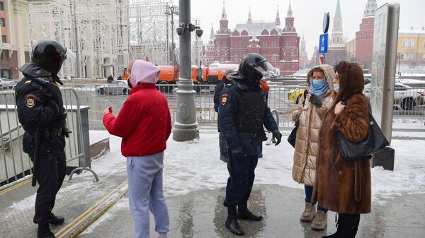Прохожие разговаривают с сотрудниками полиции у перекрытого перехода на Моховой улице в Москве