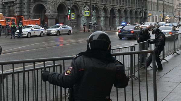 Сотрудники правоохранительных органов устанавливают ограждения на улице перед началом несанкционированной акции