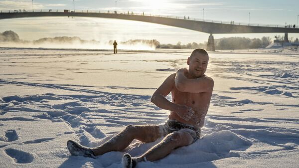 Мужчина из Новгородского клуба любителей зимнего плавания растирается снегом после купания в реке Волхов